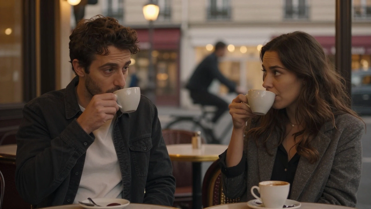 A man and woman having a quiet conversation over coffee in a Parisian café at dusk.